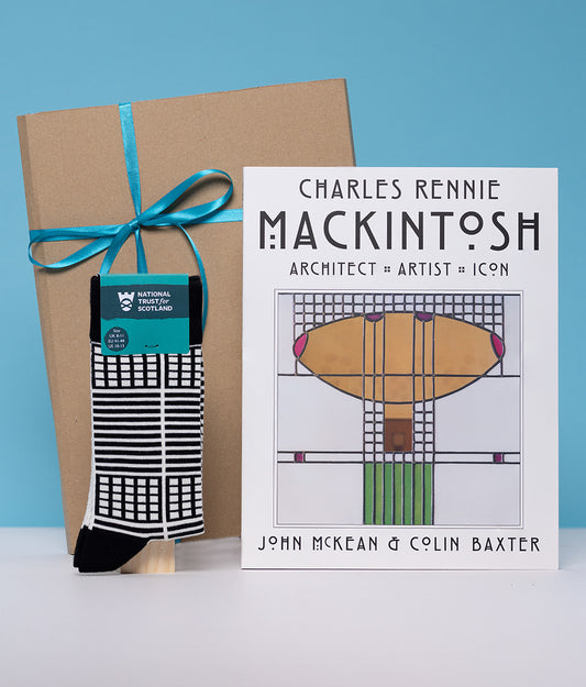 Book titled 'Charles Rennie Mackintosh' with a sock and gift box on a blue background