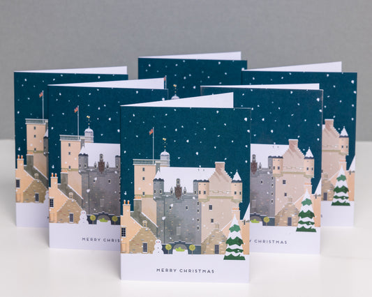 A stack of Christmas cards featuring an illustration of Castle Fraser covered in snow, with 'Merry Christmas' text visible.