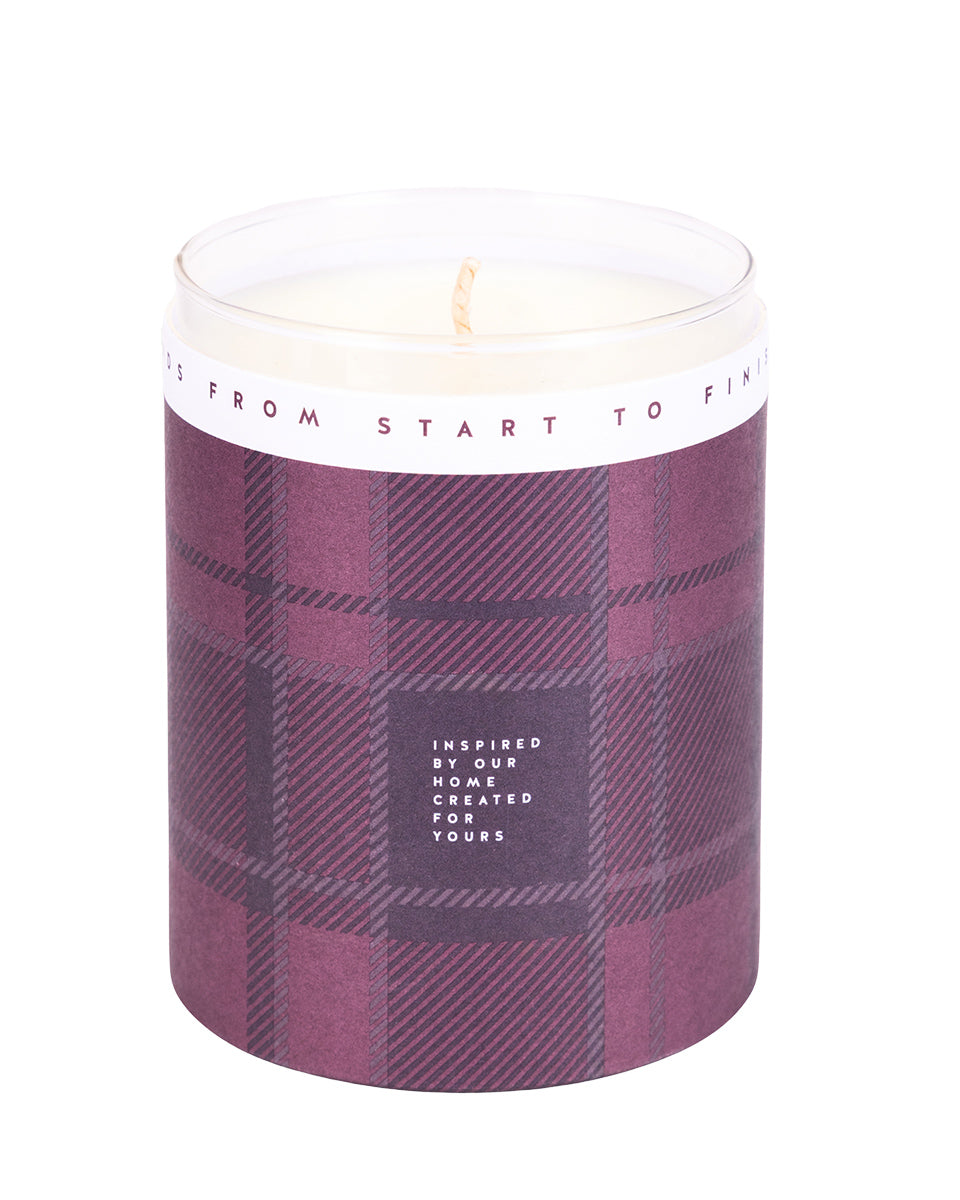 Candle in a plaid-patterned container with a white label on a light gray background