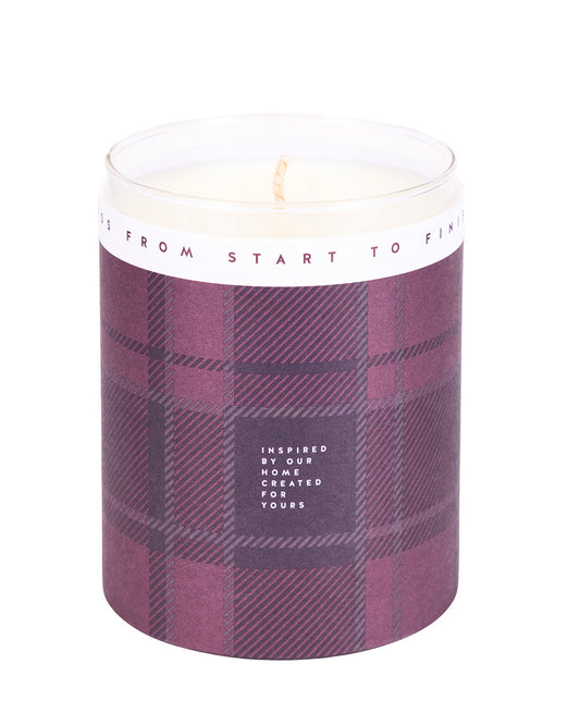Candle in a plaid-patterned container with a white label on a light gray background