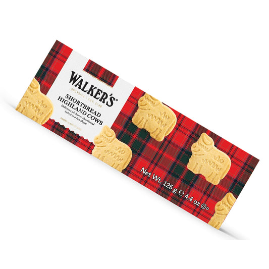 A package of Walker's Shortbread Highland Cows biscuits, featuring a red and black plaid design with illustrations of cow-shaped biscuits on a white background.