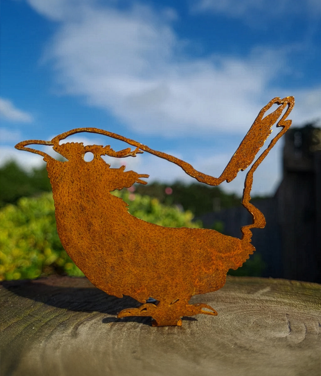 Rusted metal Wren Fence Topper sculpture of a bird on a wooden surface with a blurred natural background