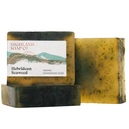 Two rectangular bars of Highland Soap Co. Hebridean Seaweed handmade soap stacked together, with one bar showing its white paper label and the other showing the textured, yellow-green seaweed-infused soap surface, set against a plain white background.