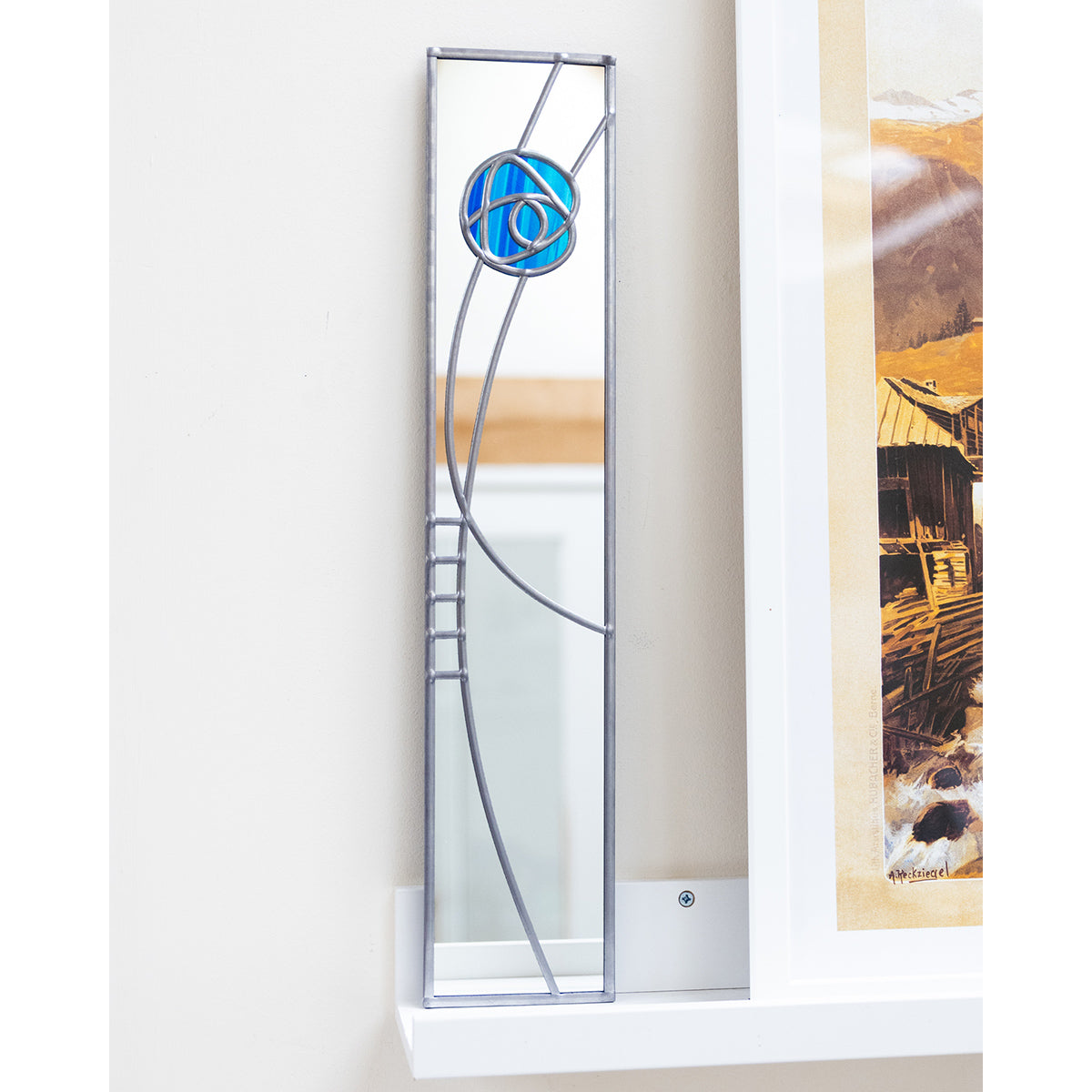 Decorative glass panel with a blue circle design on a white wall.