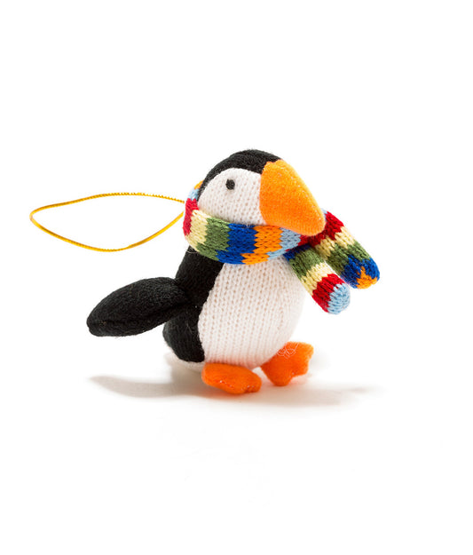 Knitted penguin ornament with a colorful scarf on a white background
