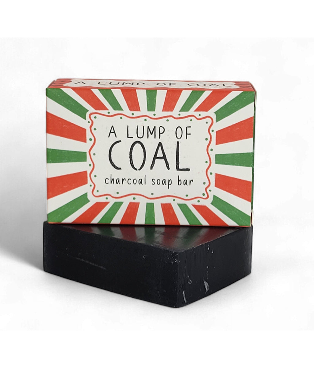 Black soap bar with a colorful box labeled 'A Lump of Coal' on a white background