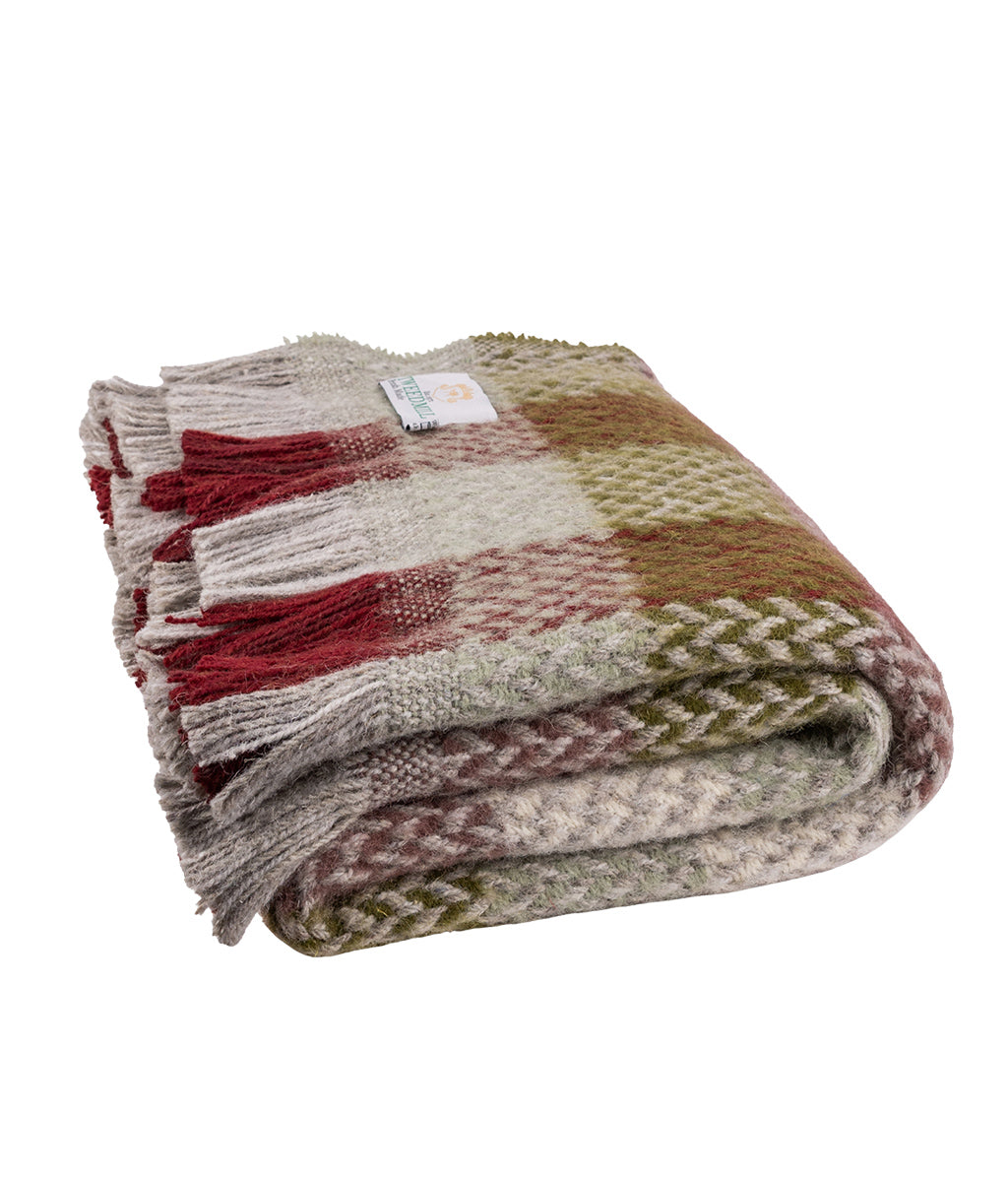 Woven blanket with a pattern of red, green, and brown on a white background