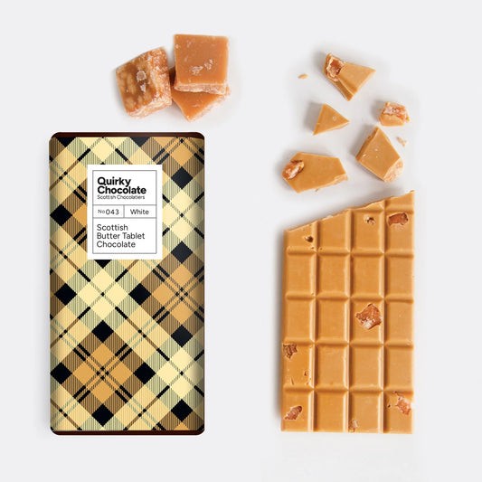 Quirky Scottish Tablet Chocolate Bar with a plaid design and a white label, accompanied by broken pieces of chocolate on a white background.