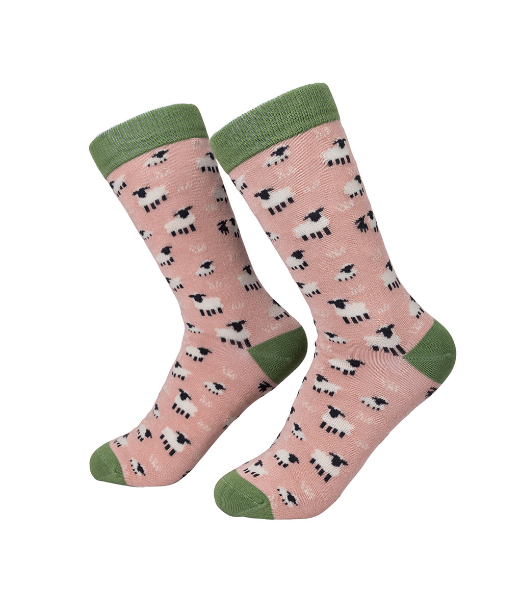 Pink socks with sheep pattern and green accents on a white background