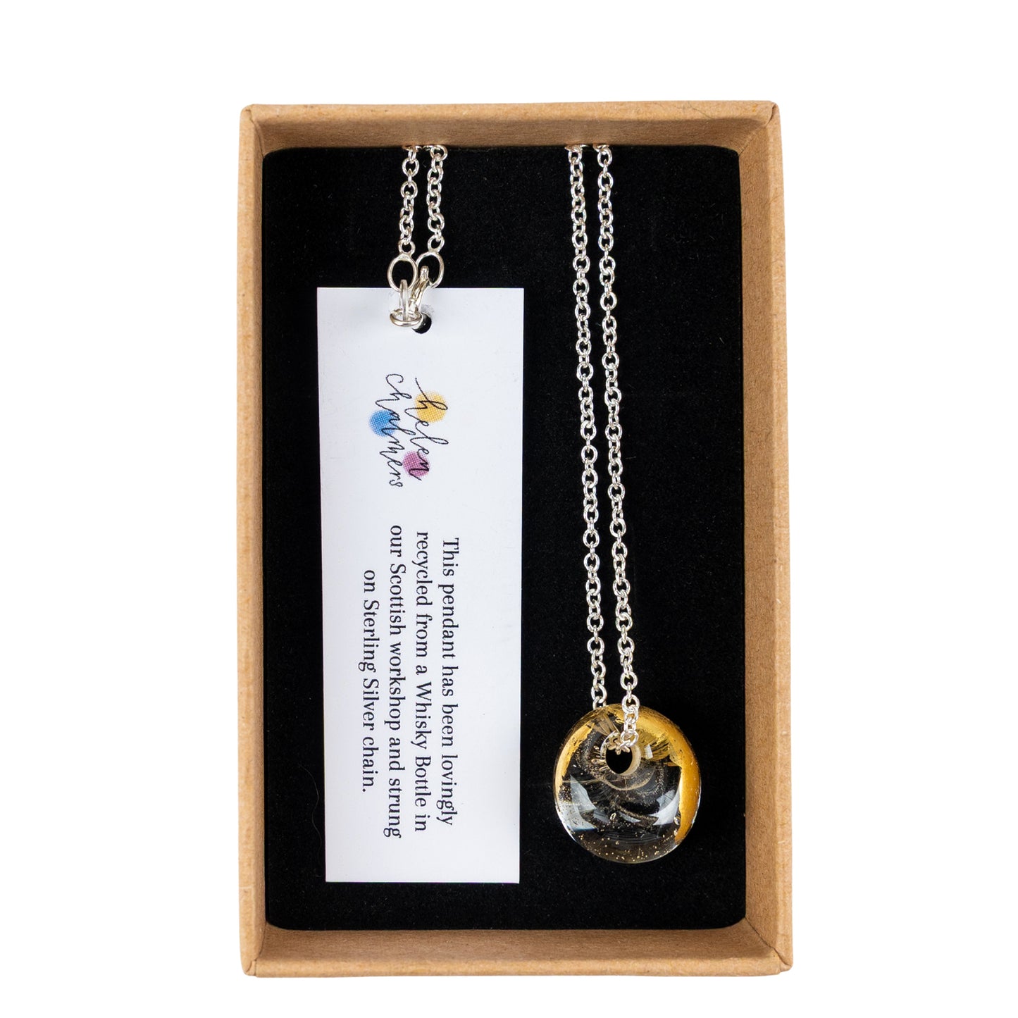 A recycled whisky bottle clear glass and gold pendant, presented inside a brown gift box with a black insert and a white product tag.