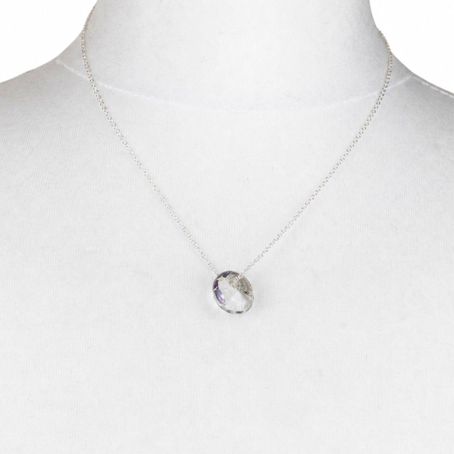 A recycled whisky bottle clear glass and palladium pendant, displayed on a white fabric mannequin bust.