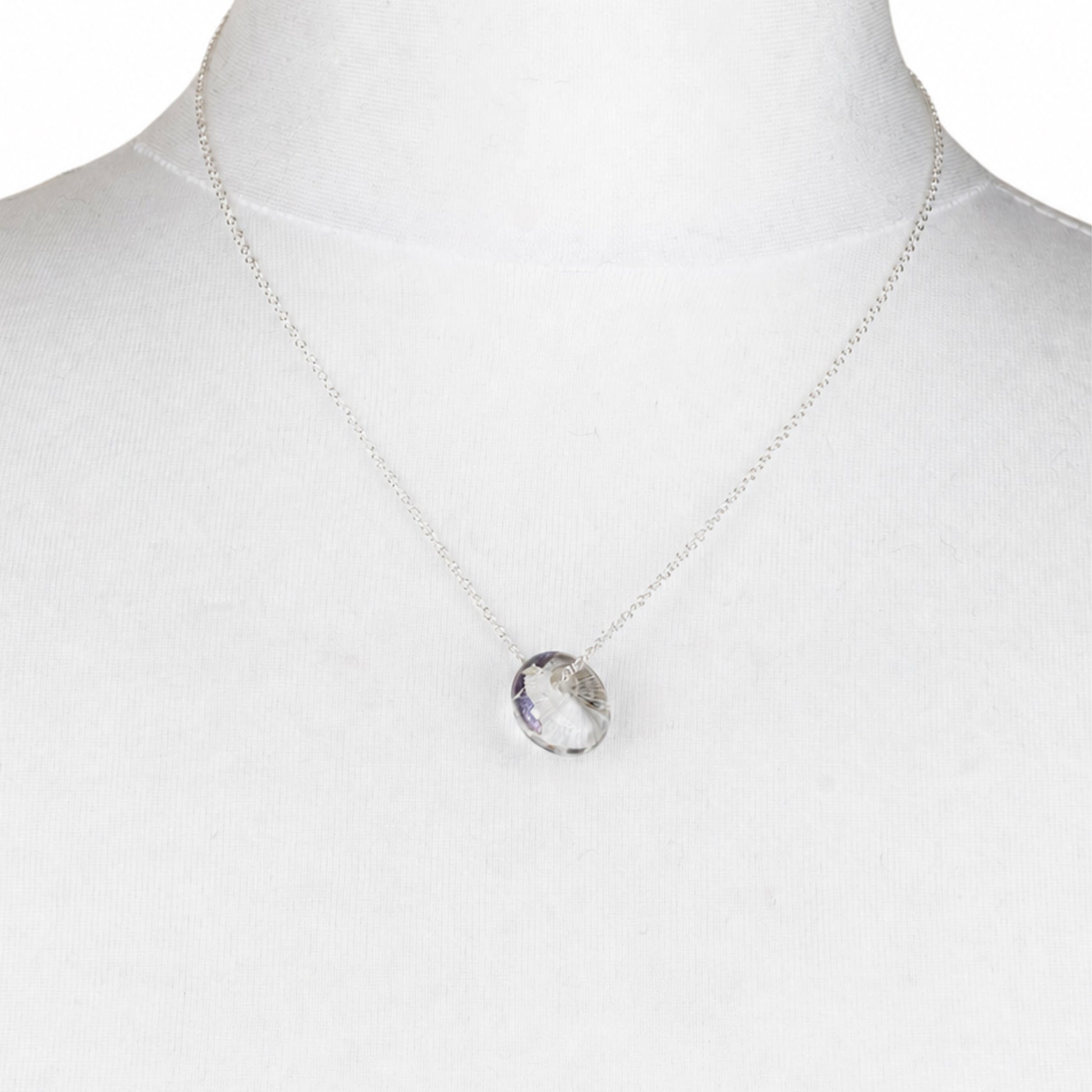 A recycled whisky bottle clear glass and palladium pendant, displayed on a white fabric mannequin bust.