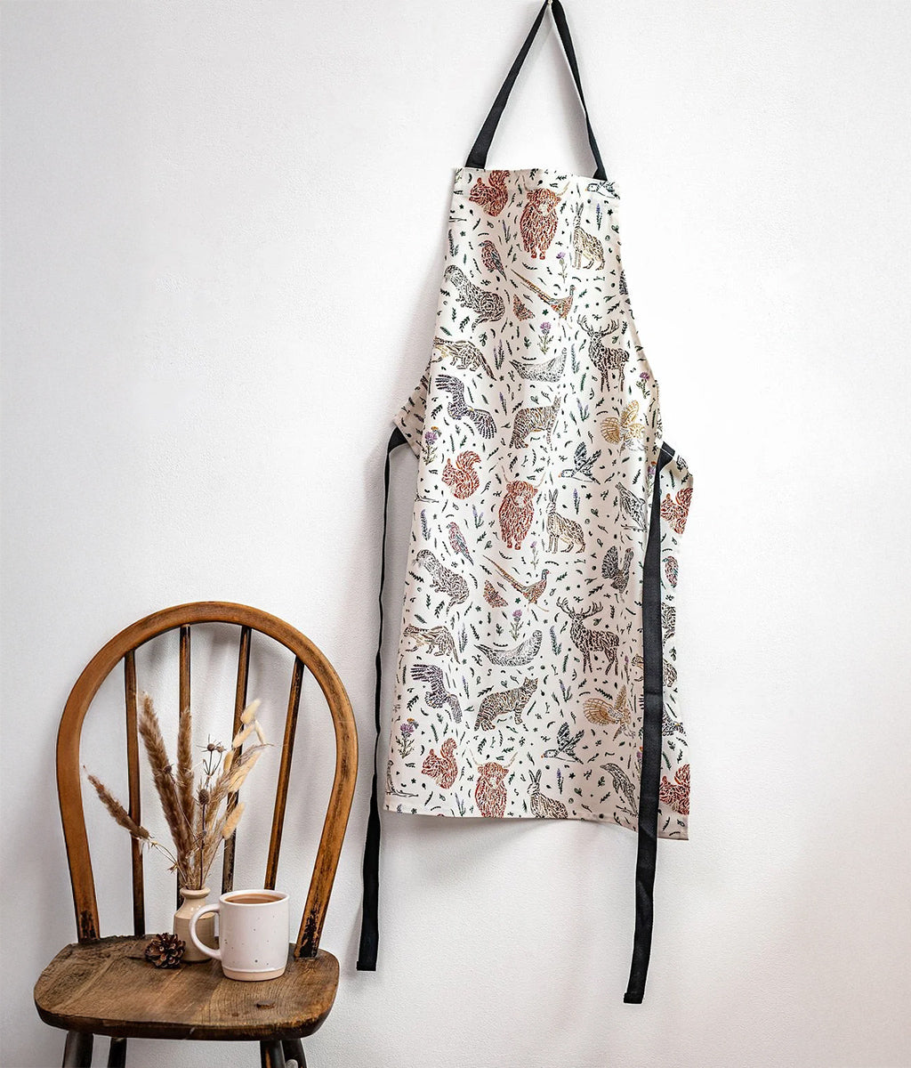 Scottish Wildlife Pattern Apron by Sarah Leask hanging on a wall