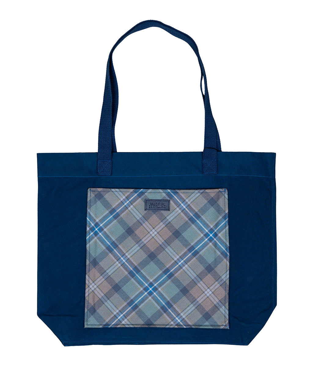 Blue tote bag with a plaid patterned pocket on a white background
