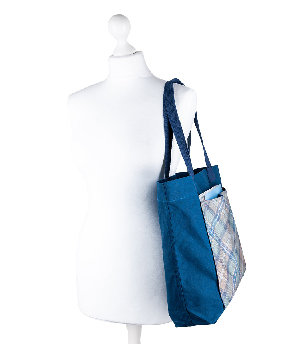 Blue tote bag with plaid lining on a white mannequin