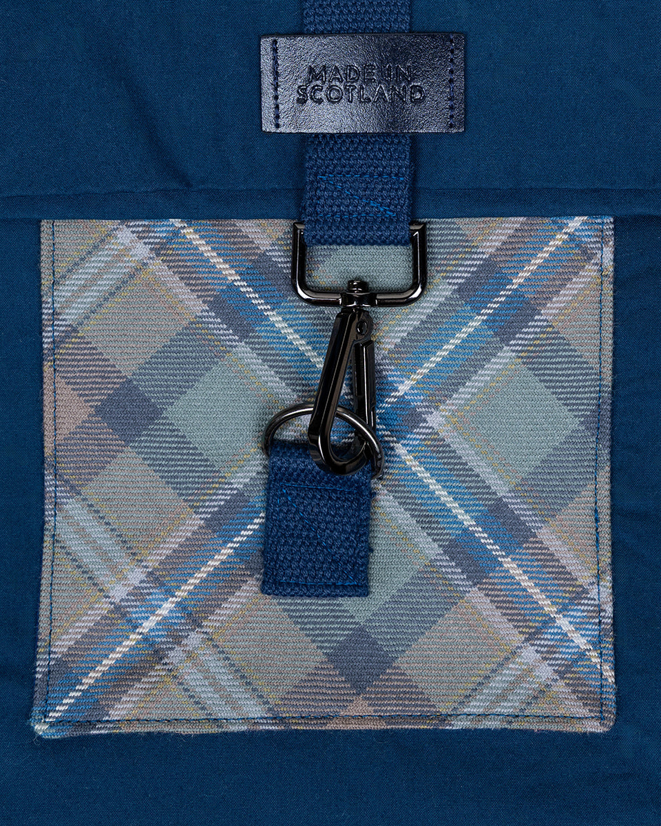 Blue plaid fabric with a keychain attached on a blue background, featuring 'Made in Scotland' label.