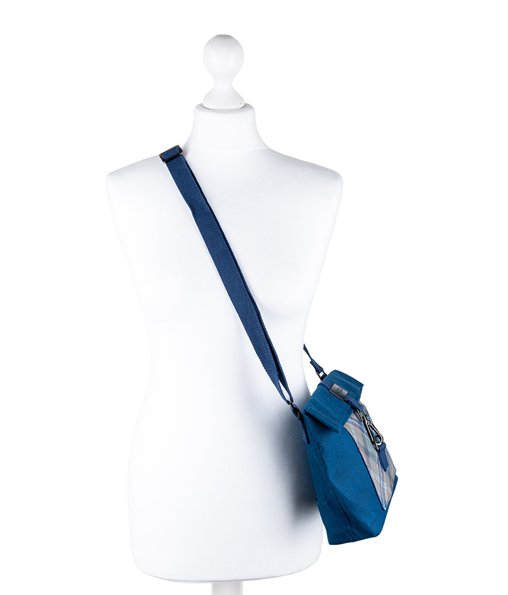 Blue crossbody bag on a mannequin against a white background