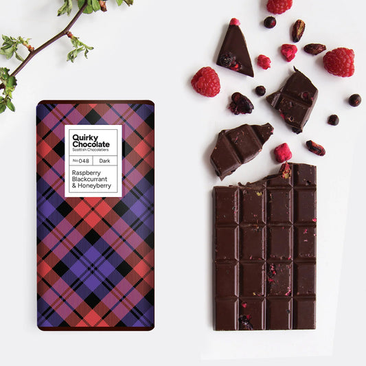 Quirky Scottish Berries Dark Chocolate Bar with plaid packaging and raspberries on a white background