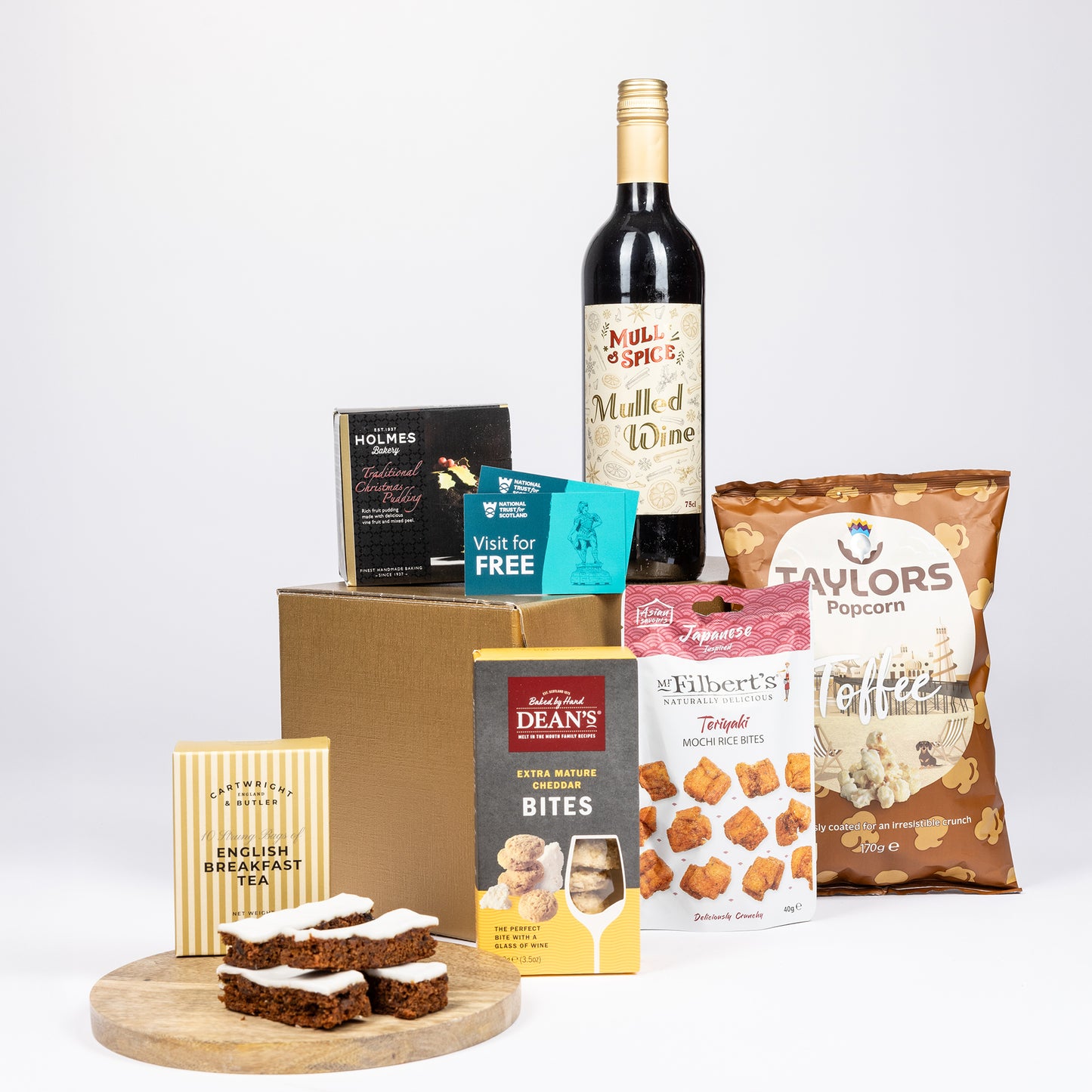 A curated gift basket arrangement featuring a bottle of Mulled Wine on a light gray background.