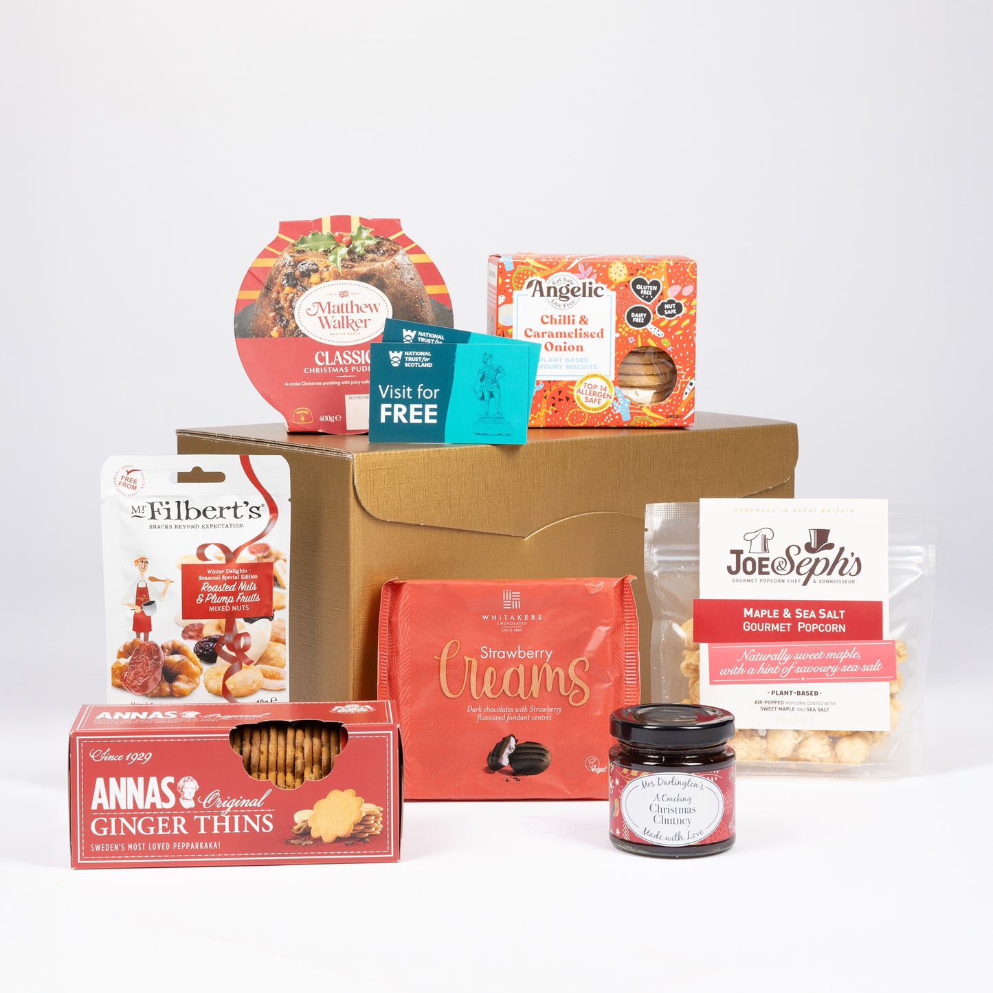 A curated vegan gift hamper featuring an assortment of food products, set against a plain white background.