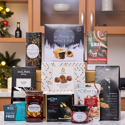 Assorted festive food products including mince pies, Christmas pudding, and other treats on a kitchen counter.