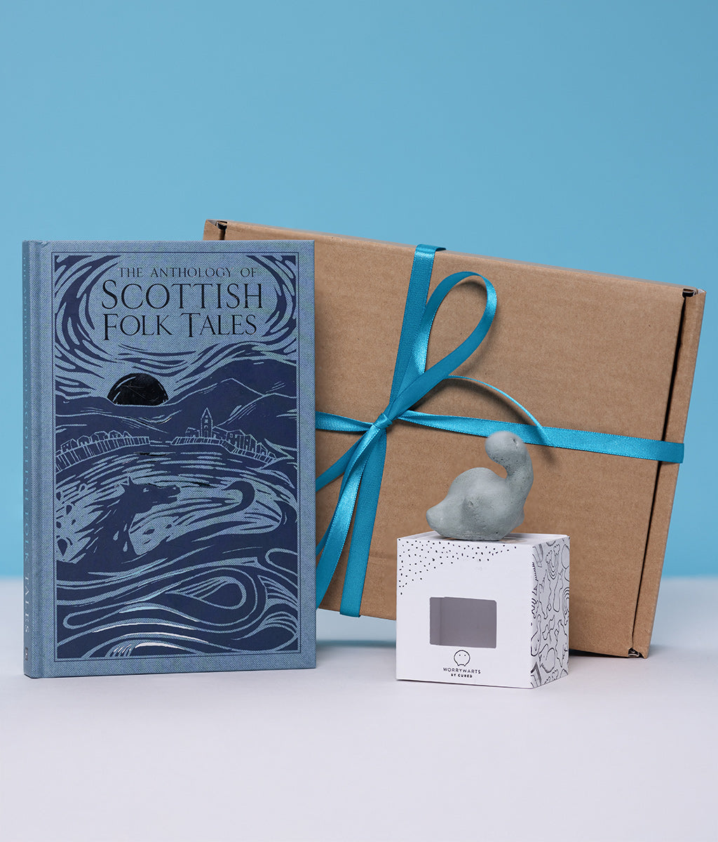 Book titled 'The Anthology of Scottish Folk Tales' with a gift box and decorative worrywart on a blue background