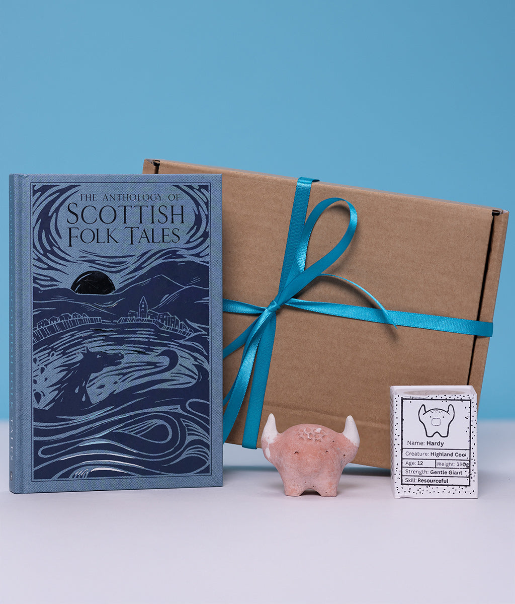 Book titled 'The Anthology of Scottish Folk Tales' with a gift box and decorative worrywart on a blue background