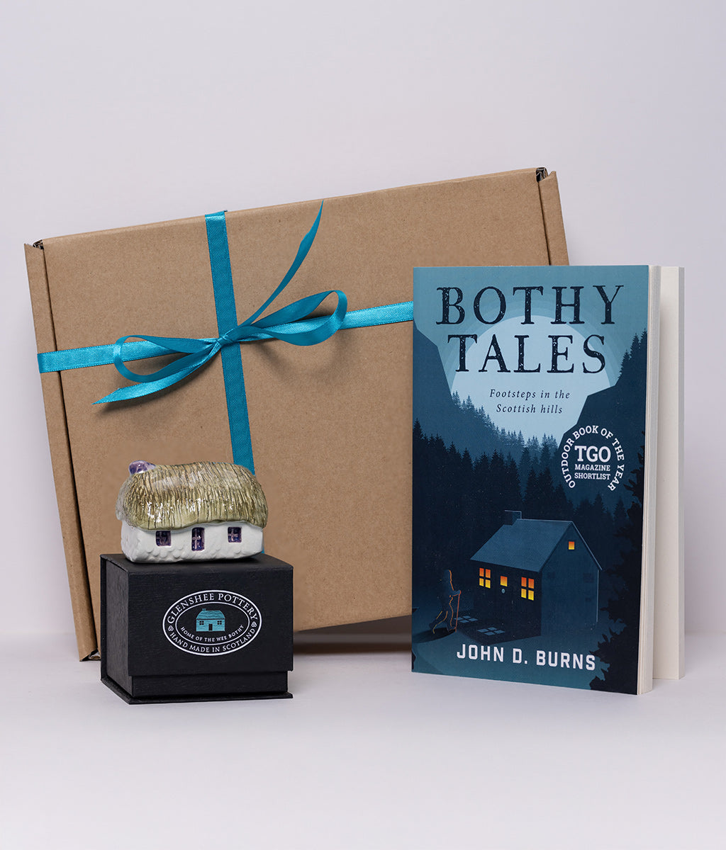 Book titled 'Bothy Tales' by John D. Burns with a small model house and gift box on a white background