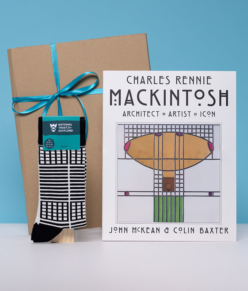 Book titled 'Charles Rennie Mackintosh' with a sock and gift box on a blue background
