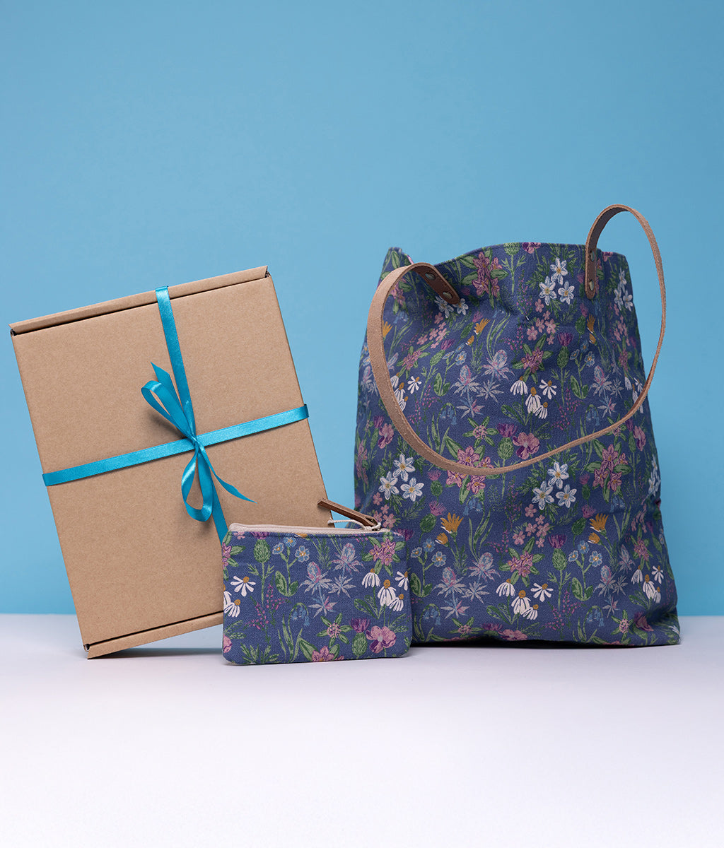 Wild Flower Purse & Bag Gift Box. Floral-patterned bag, box, and pouch on a blue background