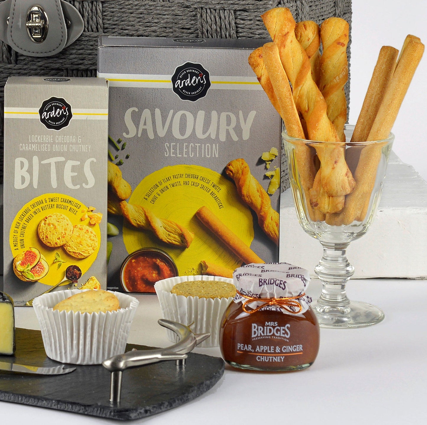 Gourmet gift set with wine, cheese, and snacks on a white background