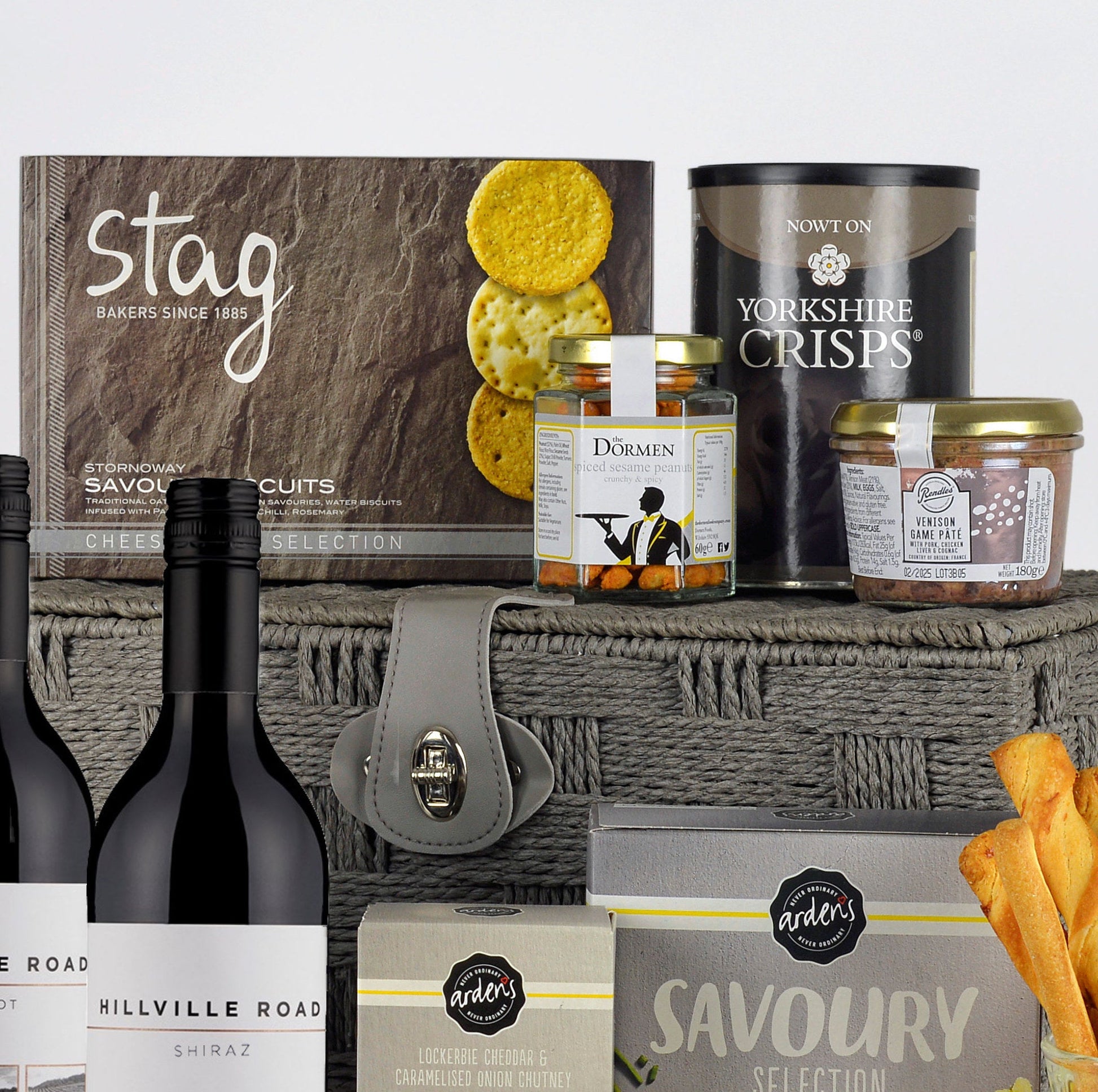 Gourmet gift set with wine, cheese, and snacks on a white background