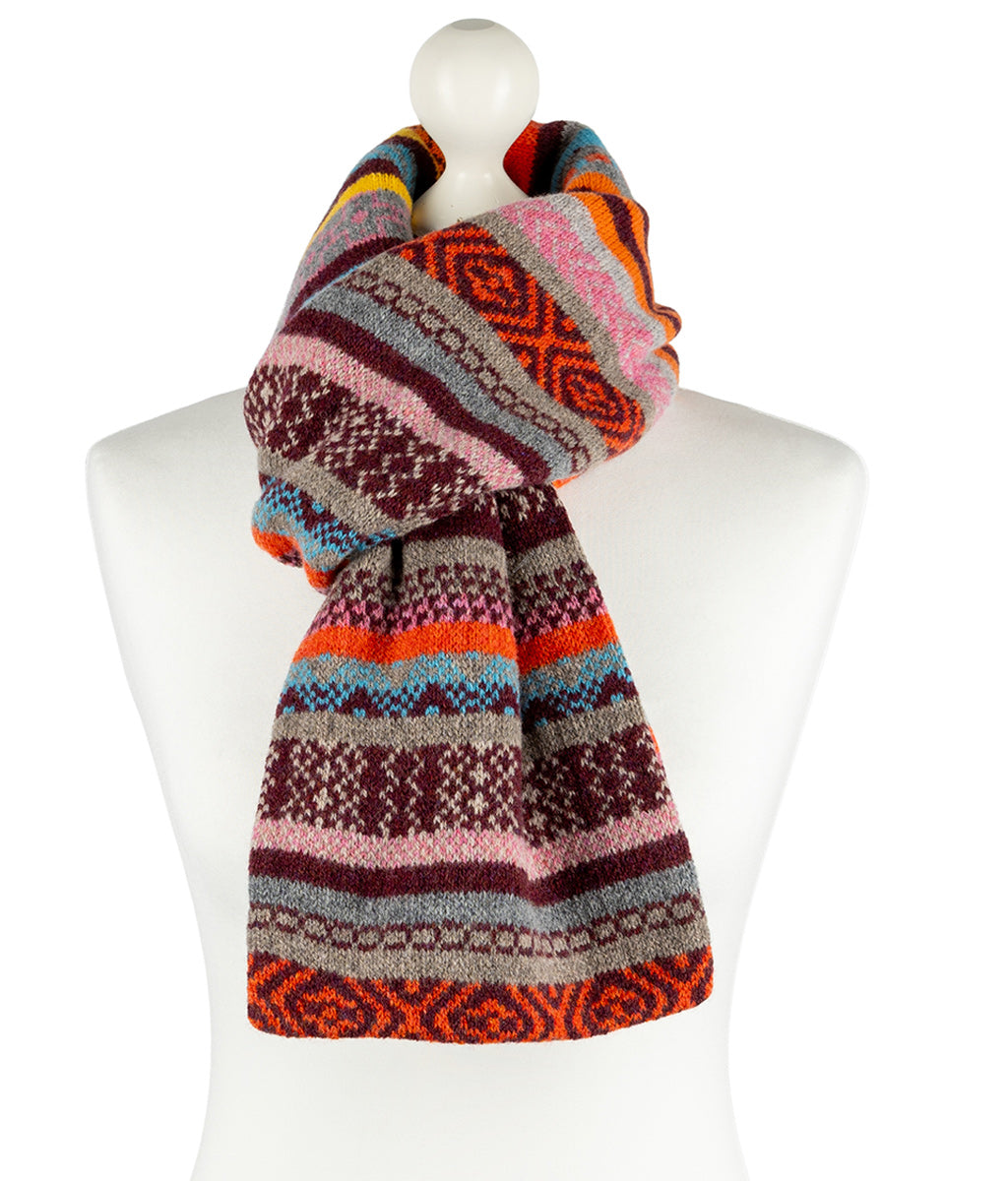 Colorful knitted scarf on a mannequin against a white background