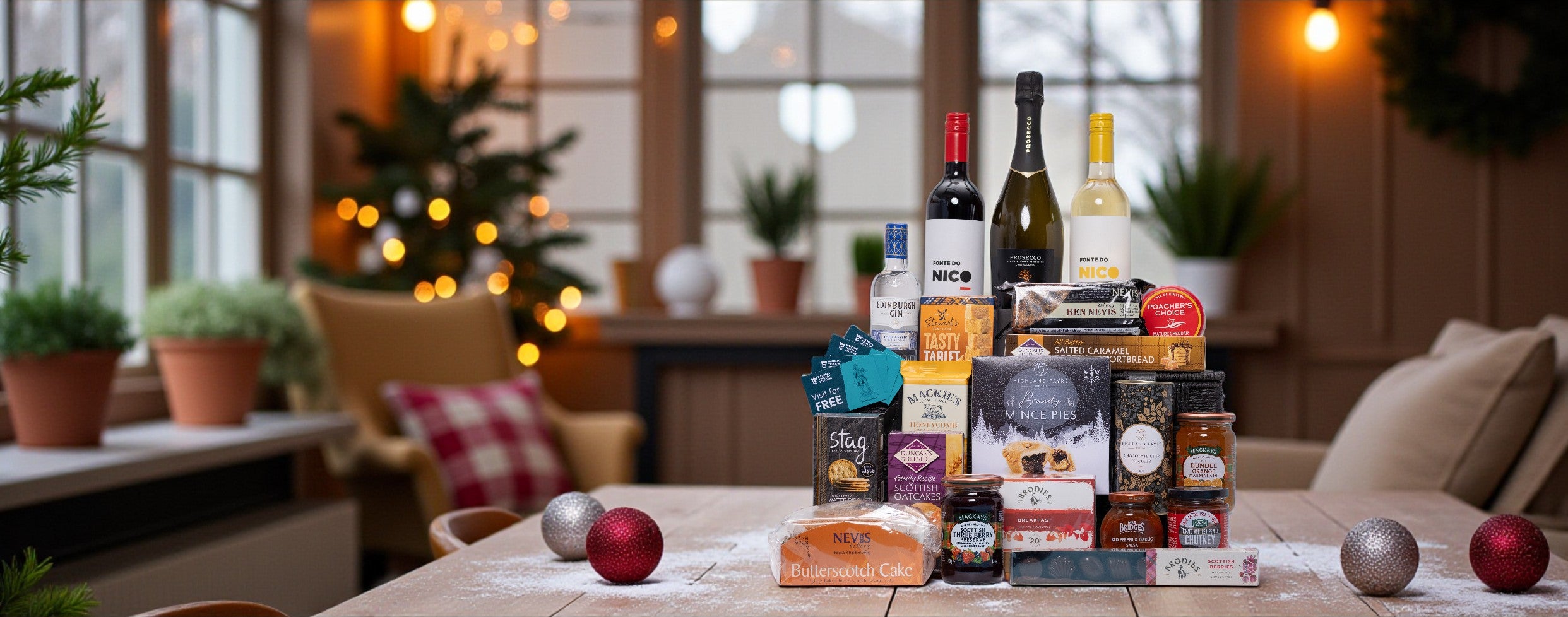 Luxury wine and food gift hamper set on a table with a cosy indoor setting in the background