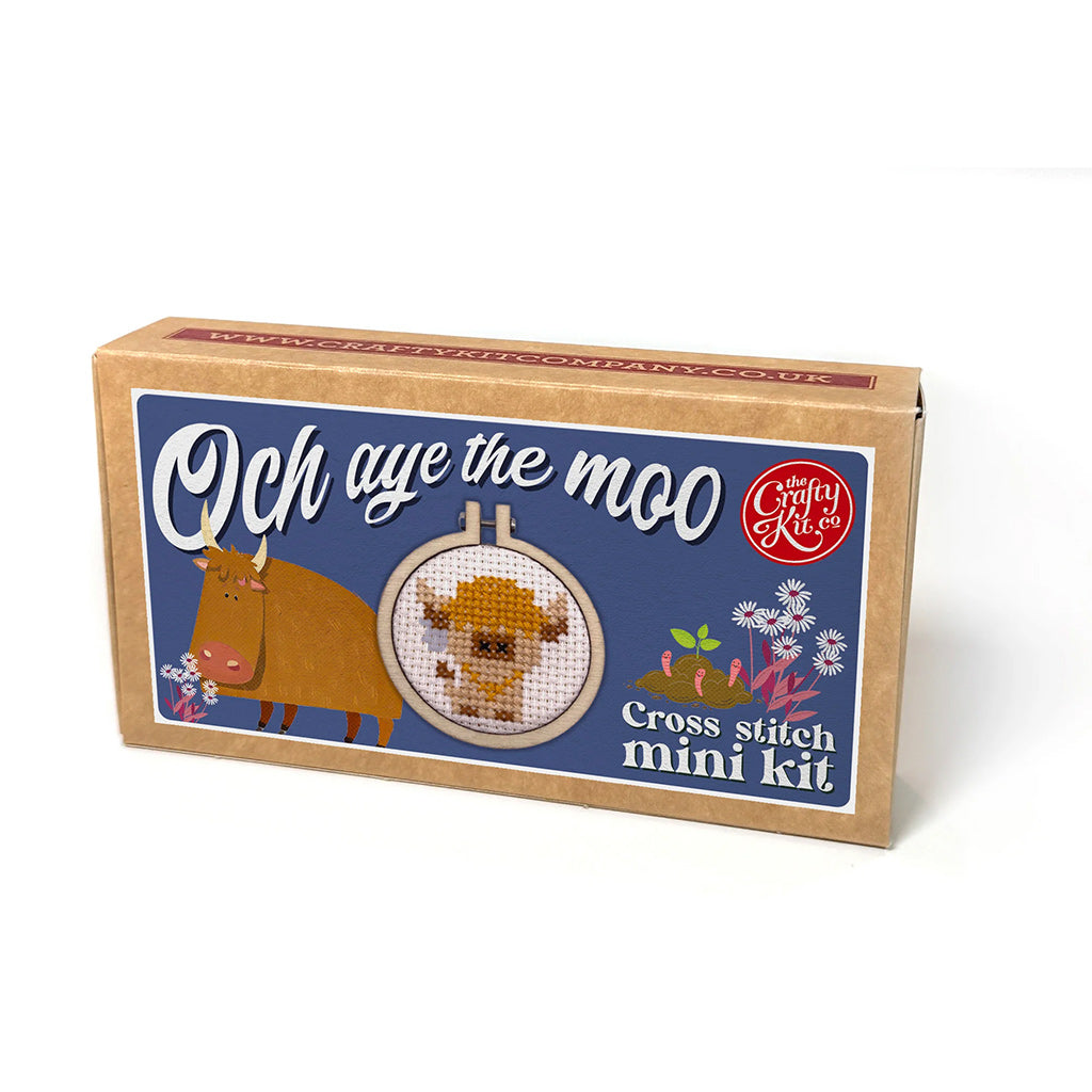 Cross stitch mini kit packaging with cow illustration and text on a white background