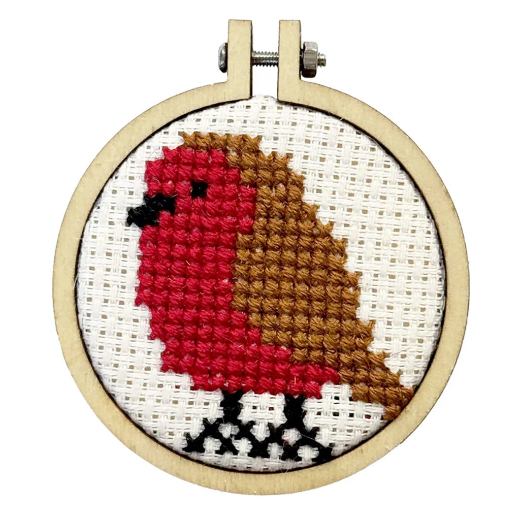 Cross-stitched cardinal in a wooden hoop on a white background