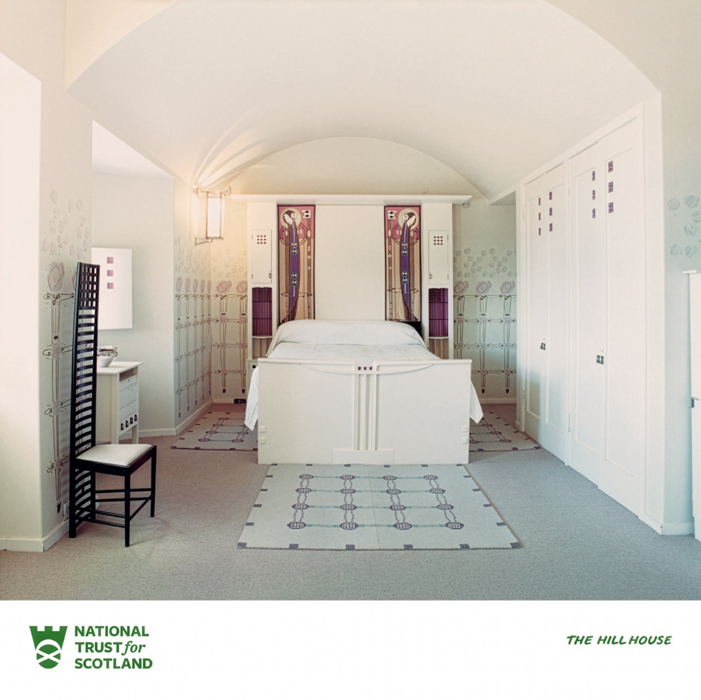 The Hill House bedroom with white bed and geometric rug, featuring National Trust for Scotland logo.