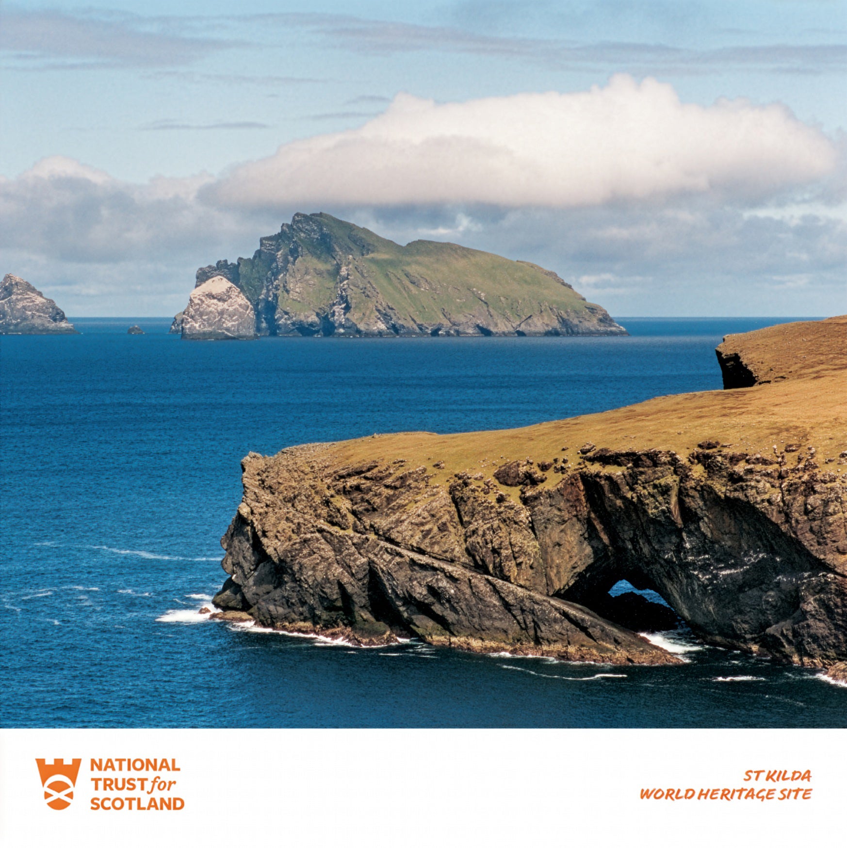 Scenic view of St Kilda with cliffs and ocean, featuring National Trust for Scotland logo.
