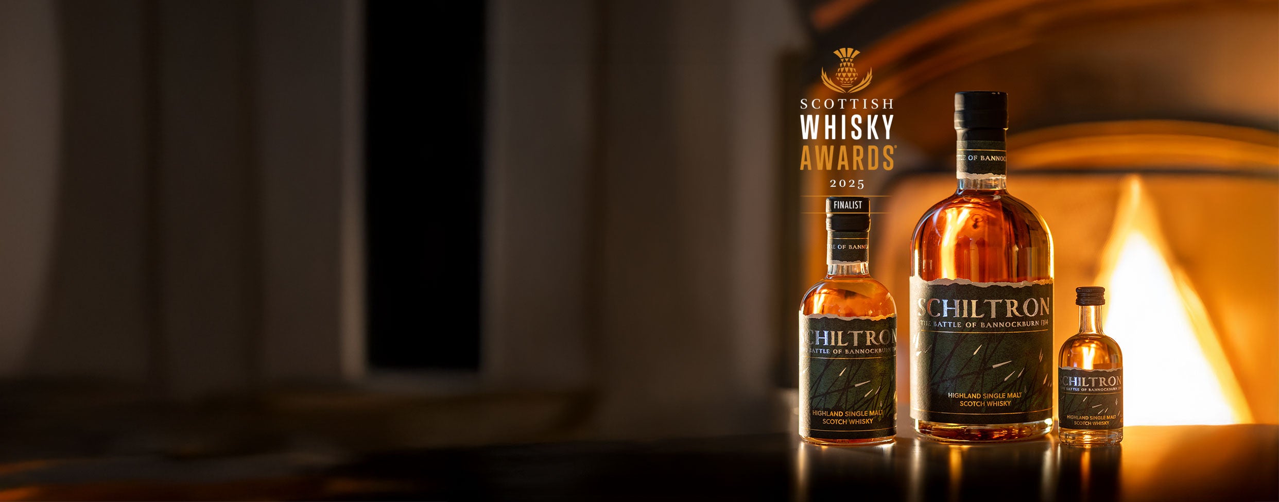 Three bottles of Schiltron whisky in front of a fireplace