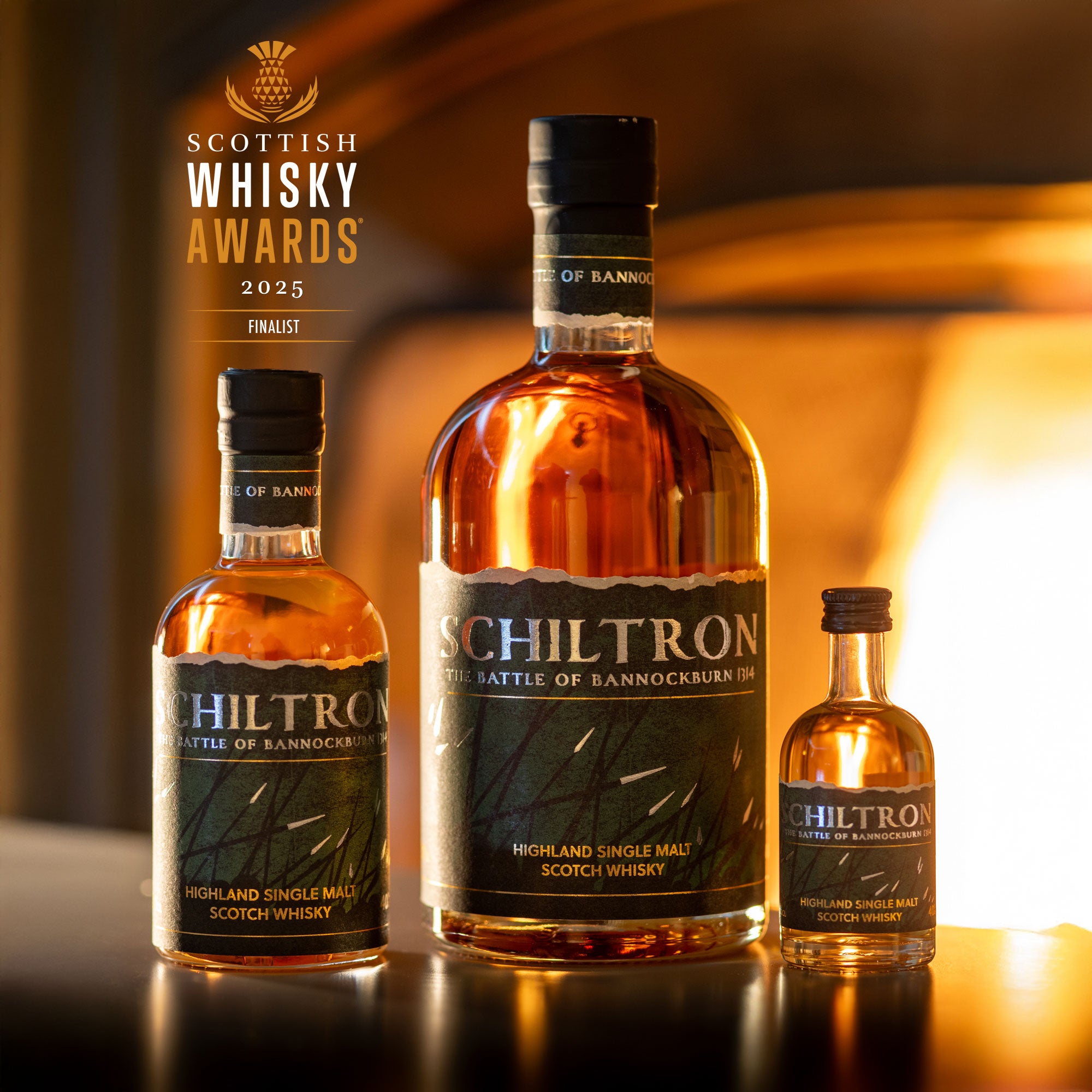 Three bottles of Schiltron whisky on a reflective surface with a warm background.
