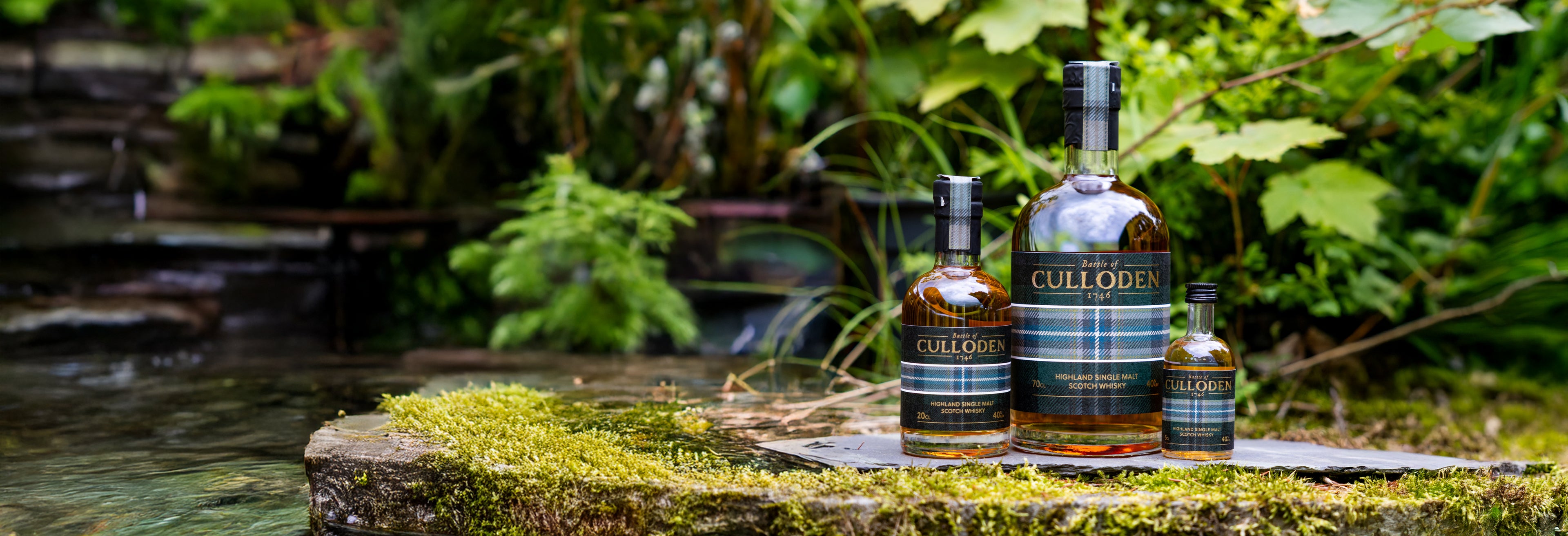 Three bottles of Cullodin whisky on a stone with a natural background