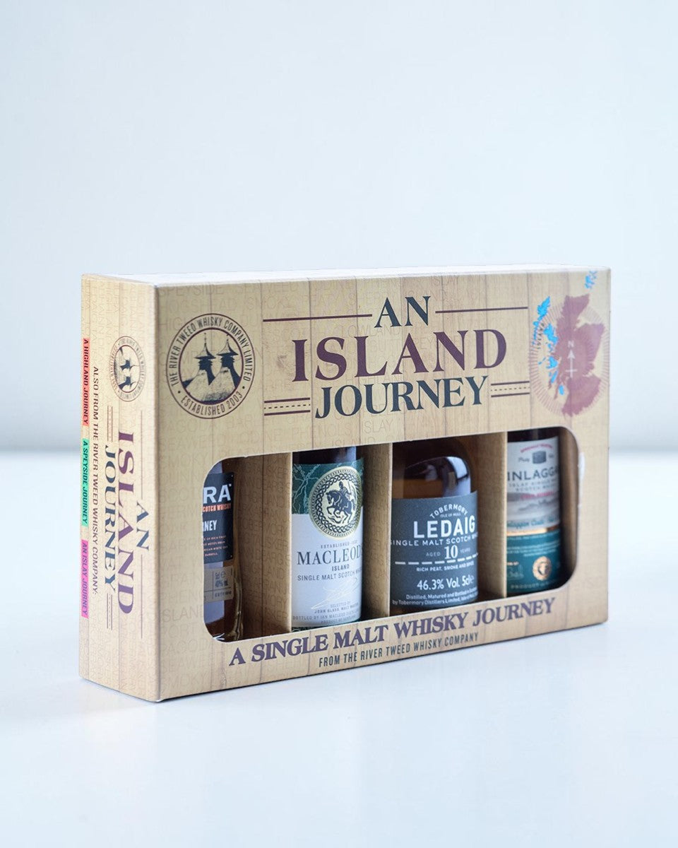 An Island Journey single malt whisky gift set containing four bottles presented in a light wood-textured box with a window display.