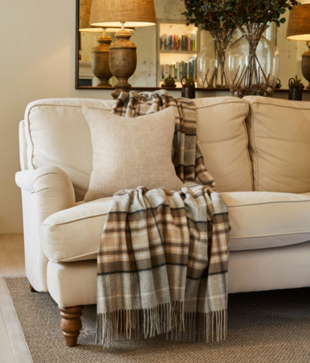 Beige sofa with McKeller Pure New Wool Throw Blanket and pillows in a living room setting